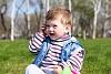 litlle boy holding mobile phone in the park