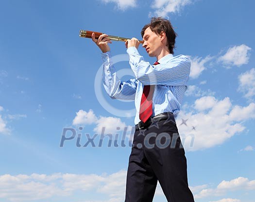 young business man in a blue shirt and red tie against the blue sky looks through a telescope. a symbol of leadership, success and freedom. young business man in a blue shirt and red tie against the blue sky looks through a telescope. a symbol of leadership, success and freedom.