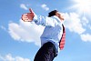 young business man in a blue shirt and red tie against the blue sky. a symbol of leadership, success and freedom.