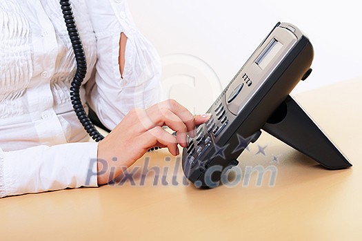 Hands of a young girl on the phone dials the number
