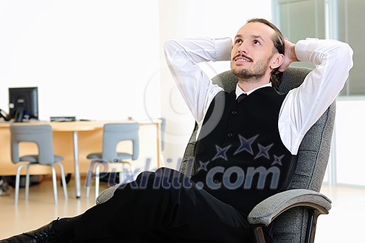 A business man in his office rests in the chair.