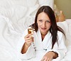 young woman with glass of champagne wearing bathrobe