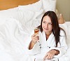 young woman with glass of champagne wearing bathrobe