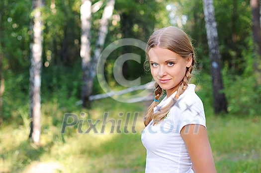 Young beautiful girl in a summer forest