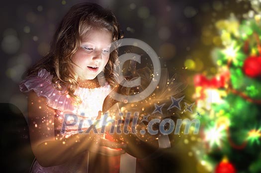 Child opening a magic gift box with lights and shining around