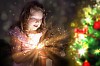 Child opening a magic gift box with lights and shining around