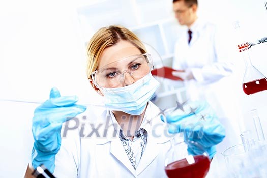 Scientist in uniform doing tests in laboratory Scientist in uniform doing tests in laboratory