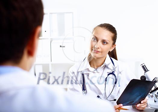 Friendly young female doctor in uniform in medical office