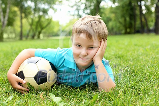 Little boy in the summer park with a ball
