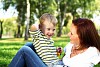 Young mother with her little son in summer park