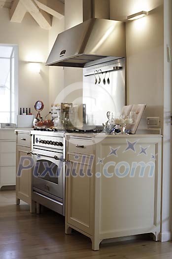 White kitchen block with steel oven and cooker hood