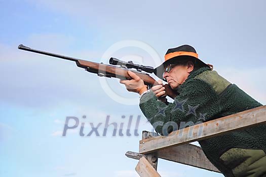 a elk or moose hunter aiming with a rifle