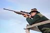 a elk or moose hunter aiming with a rifle