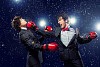 Two young businessman boxing againts dark background . conceptual collage