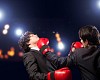 Two young businessman boxing againts dark background . conceptual collage