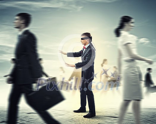 Image of businessman in blindfold walking among group of people