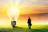 Image of businessman looking at light bulb. Green energy concept