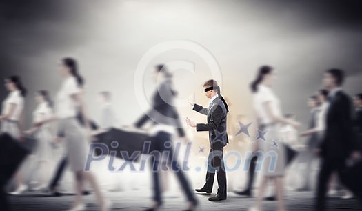 Image of businessman in blindfold walking among group of people