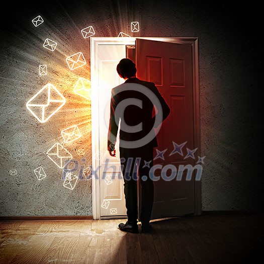 Image of young businessman standing with back opening door