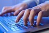 Click! Hands of a man on a keyboard with blue backlighting.