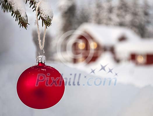 A red Christmas ball in front of a house