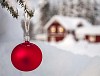 A red Christmas ball in front of a house