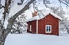 A snow covered red wooden house