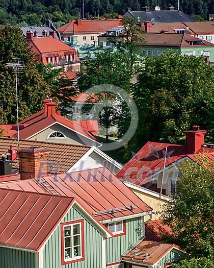 View over a city with rooftops with red tin roofs and red tile roofs