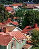 View over a city with rooftops with red tin roofs and red tile roofs