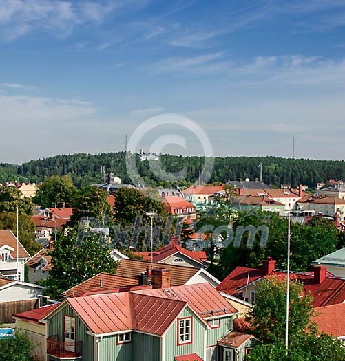 View over a city with rooftops with red tin roofs and red tile roofs