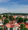 View over a city with rooftops with red tin roofs and red tile roofs