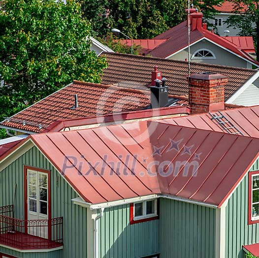View over a city with rooftops with red tin roofs and red tile roofs View over a city with rooftops with red tin roofs and red tile roofs