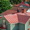 View over a city with rooftops with red tin roofs and red tile roofs