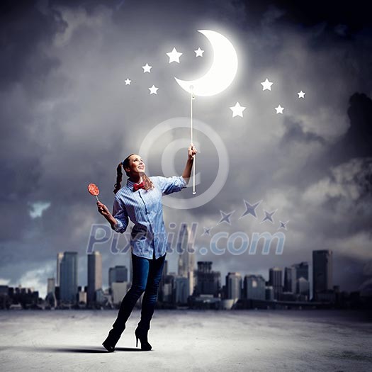 Funny teenager girl with candy against city background Funny teenager girl with candy against city background