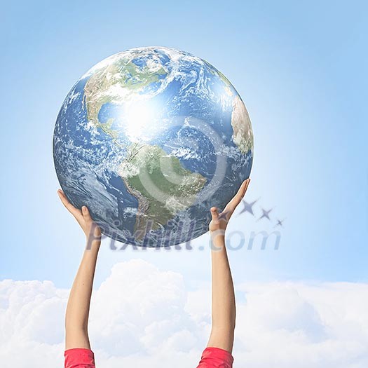 Close -up image of human hands holding globe. Elements of this image are furnished by NASA