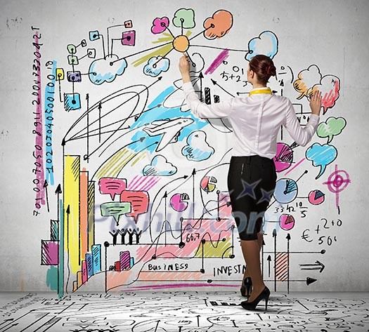 Businesswoman standing with back drawing business ideas on wall Businesswoman standing with back drawing business ideas on wall
