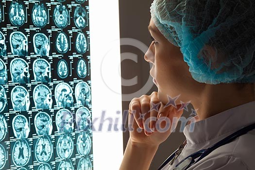 Image of attractive woman doctor looking at x-ray results Image of attractive woman doctor looking at x-ray results