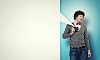 Image of young man in red tie with photo camera taking pictures