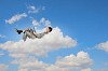 Image of businessman lying on clouds with tablet pc