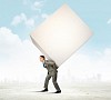 Image of businessman carrying big white cube on his back