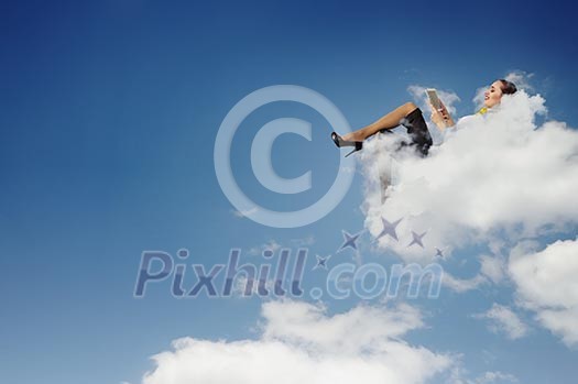 Image of businesswoman lying on clouds with tablet pc