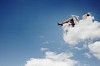 Image of businesswoman lying on clouds with tablet pc