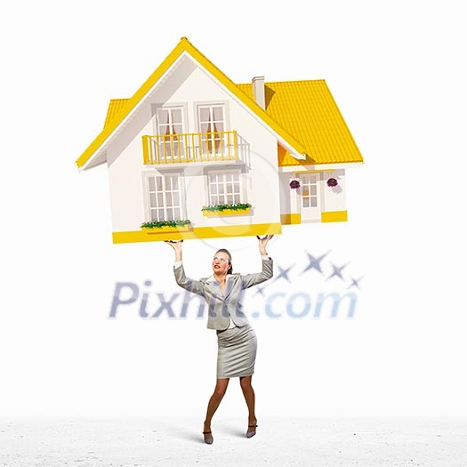 Image of businesswoman holding model of house above head Image of businesswoman holding model of house above head