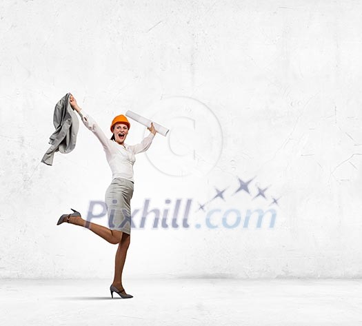 Young woman engineer in helmet jumping joyfully Young woman engineer in helmet jumping joyfully