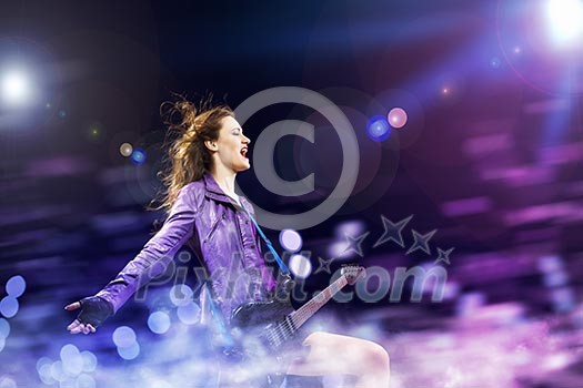 Young attractive rock girl playing the electric guitar