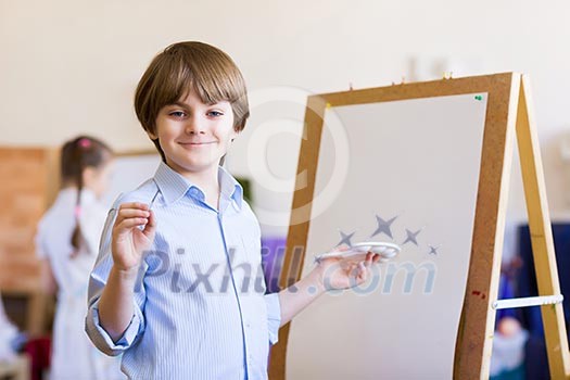 Image of little cute boy painting pictures at kindergarten Image of little cute boy painting pictures at kindergarten