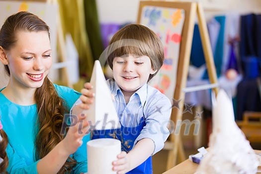 Young teacher and children painting and playing