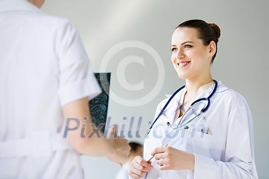 Attractive young female doctor examining x-ray results