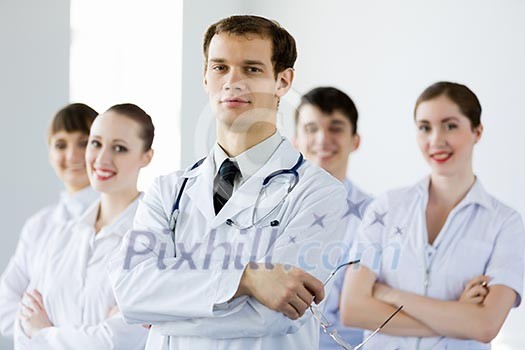 Young doctor in uniform and colleagues at background Young doctor in uniform and colleagues at background