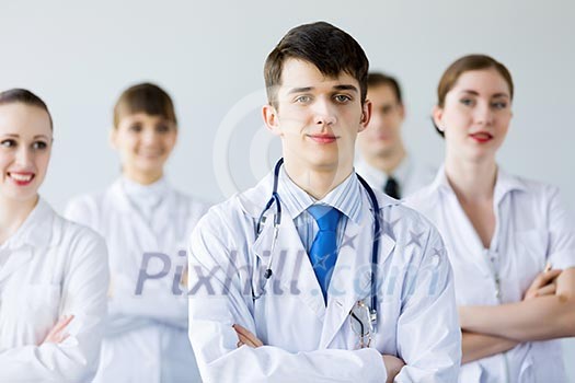 Young doctor in uniform and colleagues at background Young doctor in uniform and colleagues at background